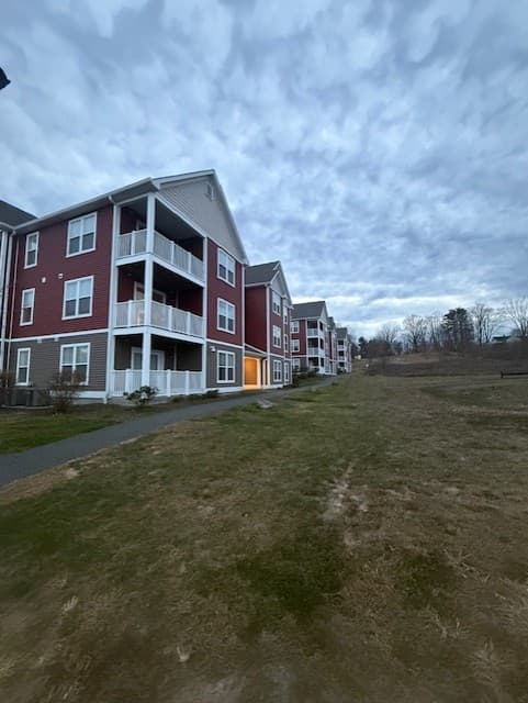Angled view along a row of Brook Hill Village buildings beside a wide open lawn