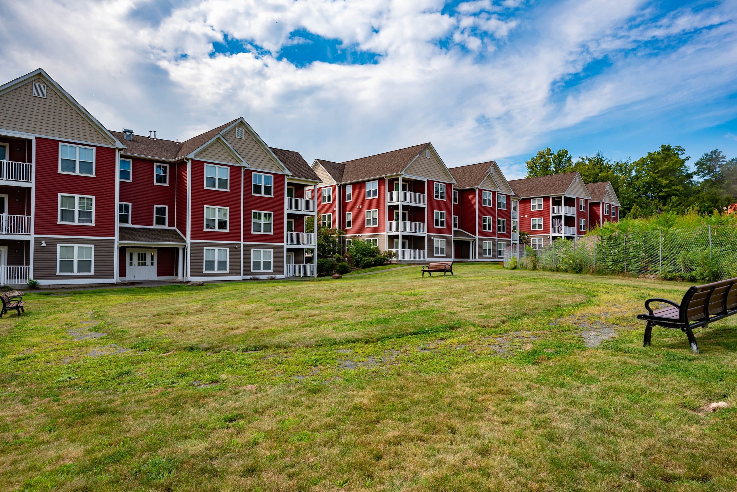 The open lawn at Brook Hill Village with benches, bordered by the apartment buildings